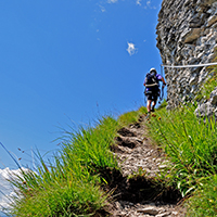 Aufstieg auf den Flimserstein über den Klettersteig Pinut über ein schmales Grasband.