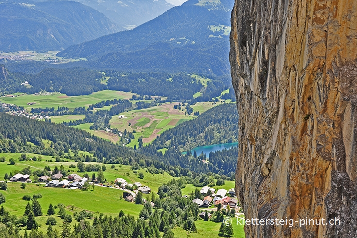 Ausblick vorbei am Meilerstein hinuner auf den Crestasee Ausblick vorbei am Meilerstein hinuner auf den Crestasee
